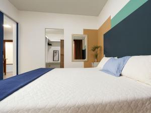 a bedroom with a large bed with a blue wall at Casa Privativa 2 Quartos em Condomínio, Suite com Cama King e Closet, Quarto de Casal, Ar, Wi-Fi, Cozinha Completa e Garagem in Porto Seguro