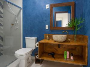 a bathroom with a toilet and a sink and a mirror at Casa Privativa 2 Quartos em Condomínio, Suite com Cama King e Closet, Quarto de Casal, Ar, Wi-Fi, Cozinha Completa e Garagem in Porto Seguro +33 photos