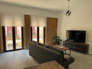 a living room with a couch and a flat screen tv at Apartamento Rosina Ávila Center in Avila