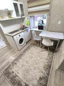 una cucina con lavatrice e tavolo di Комфортный дом до 4х человек. Есть парковка на 2 машины, Wi-Fi, TV. a Bishkek