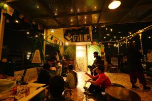 a group of people sitting in a room with lights at Whereabout Hostel Udaipur in Udaipur