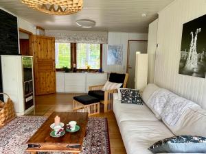 a living room with a white couch and a table at Lumossa Aurora Lakeside House in Rovaniemi