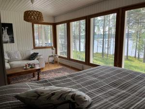 a bedroom with a bed and a couch and windows at Lumossa Aurora Lakeside House in Rovaniemi +50 photos