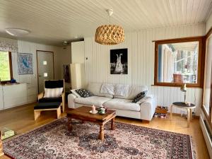 a living room with a couch and a table at Lumossa Aurora Lakeside House in Rovaniemi