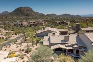 arial view of a house with mountains in the background at Tranquility at The Rocks Club/Troon in Scottsdale