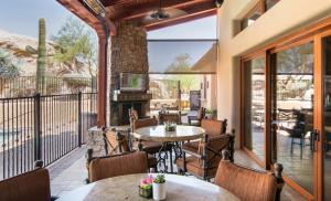 an outdoor patio with tables and chairs and a fireplace at Tranquility at The Rocks Club/Troon in Scottsdale