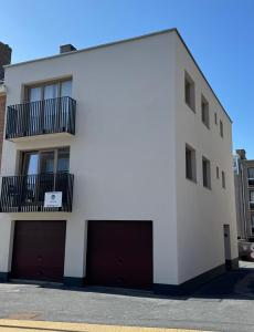 a white building with two garage doors at Fiets & Zee - Bike & Sea in Ostend