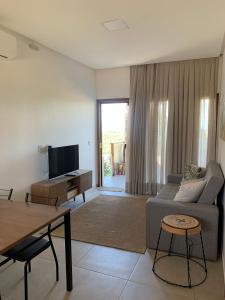 a living room with a couch and a table at Chalé I - Village da Serra in Serra de São Bento