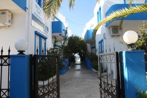 a walkway through the blue and white buildings at Creta Sun Apartments in Makry Gialos
