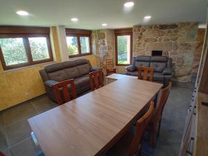 Una sala de estar con una gran mesa y sillas de madera. en A Casa da Ponte, en Negreira