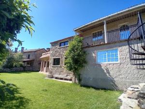 Casa de piedra con balcón y patio en A Casa da Ponte, en Negreira