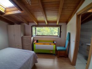 Un dormitorio con una cama y un escritorio y una ventana. en A Casa da Ponte, en Negreira