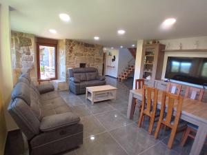 una sala de estar con un sofá y una mesa en A Casa da Ponte, en Negreira