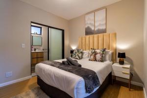 a bedroom with a large bed with a wooden headboard at #AlimamaSpaces The Rob's Akaru in Johannesburg