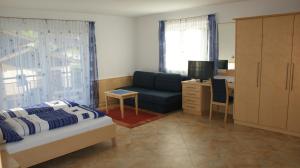 ニーダーンジルにあるFerienhaus Wieserのソファ、デスク、テレビが備わるベッドルーム1室が備わります。