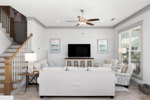 a living room with a white couch and a flat screen tv at Endless Summer in Gulf Shores