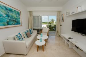un salon avec un canapé et une télévision dans l'établissement Apartamento moderno en Cana Rock B136 - Punta Cana, à Punta Cana