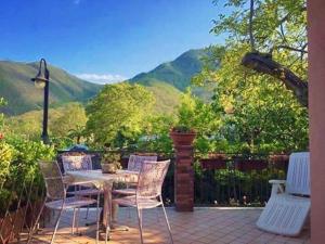 a patio with a table and chairs and a view of mountains at Green Sunset in Tramonti