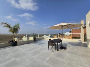 a patio with a table and an umbrella at המקום של אסי - Assi's place in Oshrat