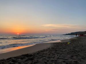 a sunset on a beach with the ocean at Marigiò in Menfi