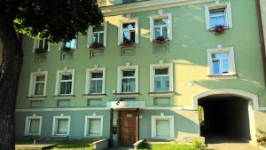un edificio verde con puerta y ventanas en Lvovo Apartments, en Vilna