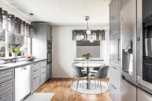 a kitchen with a table and chairs in it at Modern stor & ljus villa nära centrum in Växjö +22 photos