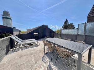 ein Holztisch und Stühle auf einer Terrasse in der Unterkunft Wohnung Bel Etage im historischen Amtshaus in Fehmarn