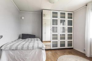 a white bedroom with a bed and a closet at Modern stor & ljus villa nära centrum in Växjö
