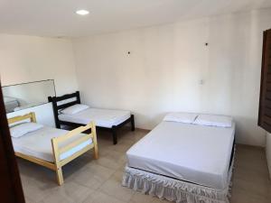 a room with two beds and a chair in it at Casa dunna azul in Trairi
