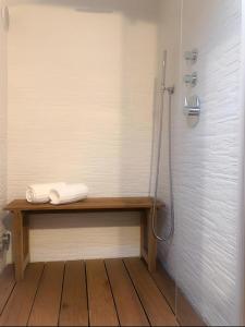 a bathroom with a shower and a wooden bench with a shower at Leonville Luxury Apartment in Roccaraso