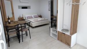 a bedroom with a bed and a table and a dining room at Maras studio apartmani, Vinkovci in Vinkovci