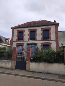 a red and white house with a black gate at L'appart in Vinneuf