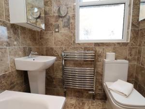 Un baño con lavabo, inodoro y ventana. en All Seasons House, en Filey 18 fotos más
