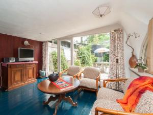 a living room with a table and chairs and a tv at Holiday Home Bergen near Forest & Beach in Bergen +15 photos