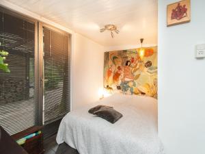 a bedroom with a bed and a painting on the wall at Holiday Home Bergen near Forest & Beach in Bergen