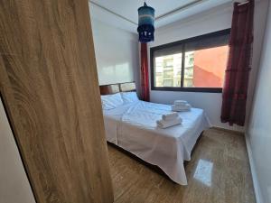 a small bedroom with a bed and a window at Casablanca Yamanda Appartement - Ain Sebaa in Casablanca