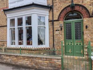 una puerta verde y una ventana en un edificio de ladrillo en All Seasons House, en Filey