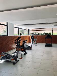 a gym with three exercise bikes in a room with windows at Modern 265m2 Flat BBQ Pool Gym in Asuncion