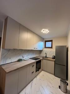 a kitchen with white cabinets and a stainless steel refrigerator at Casa Due in Novi Sad