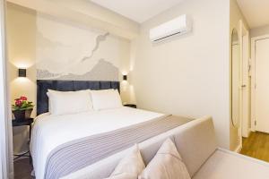 Un dormitorio con una gran cama blanca en una habitación. en JP Redenção by My Way, en Porto Alegre 15 fotos más