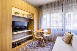 Una habitación de hotel con una mesa y un televisor. en JP Redenção by My Way, en Porto Alegre