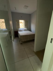 Un dormitorio con una cama y dos ventanas. en A hospedaria, en Sete Lagoas