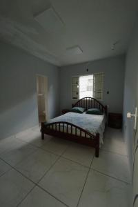 Un dormitorio con una cama en una habitación con ventana. en A hospedaria, en Sete Lagoas