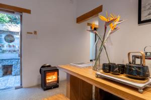 a table with a vase of flowers and a fireplace at Granite Forest Chalet in Cape Town