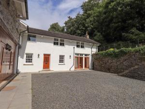 a white house with red doors and a driveway at Abbots Reading Cottage in Lakeside