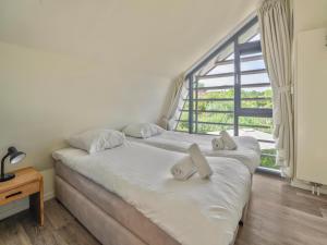 a bedroom with a bed and a large window at Beautiful holiday home with terrace in Egmond aan den Hoef