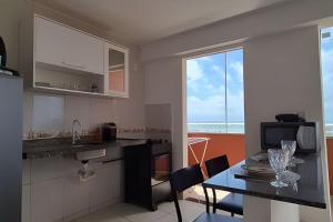 a kitchen with a table and a dining room at Flat beira-mar Natal in Natal