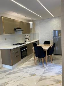 y cocina con mesa, sillas y fogones. en For rent T3 beachfront Mehdia, en Kenitra