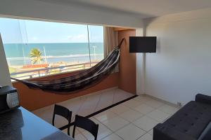 a room with a hammock and a view of the beach at Flat beira-mar Natal in Natal