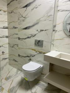 Un baño con un inodoro blanco y un lavabo. en For rent T3 beachfront Mehdia, en Kenitra